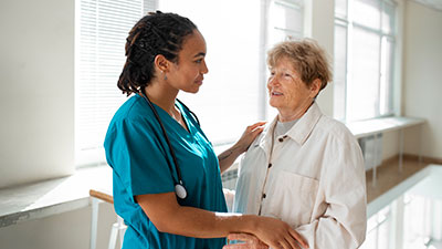 Médica especializada em geriatria em Pelotas RS conversando com idosa.